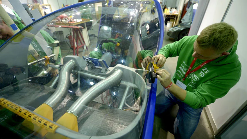 Etudiant travaillant sur un véhicule électrique lors de l'Eco-shell marathon 2015