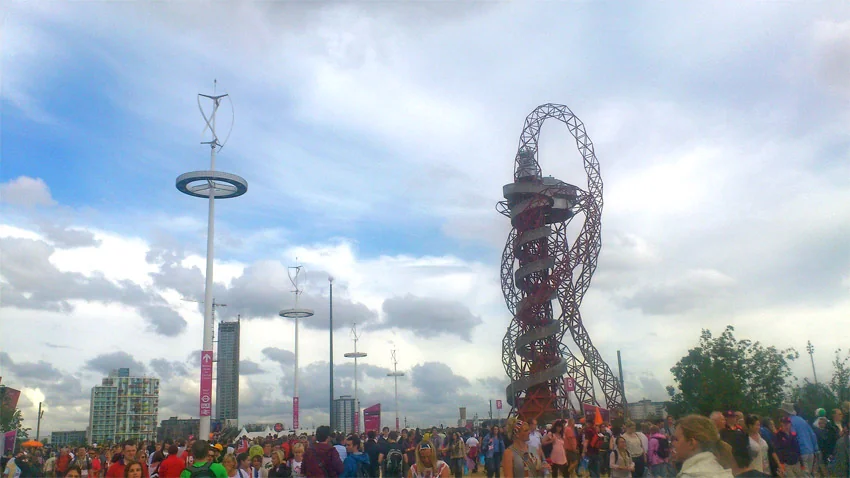 Hauts de 18 m, les mâts des éoliennes surplombent les nombreux spectateurs. Face à elles, la tour Orbit de Mittal Arcelor, dessinée par Anish Kapoor, s’élève à plus de 115 m.