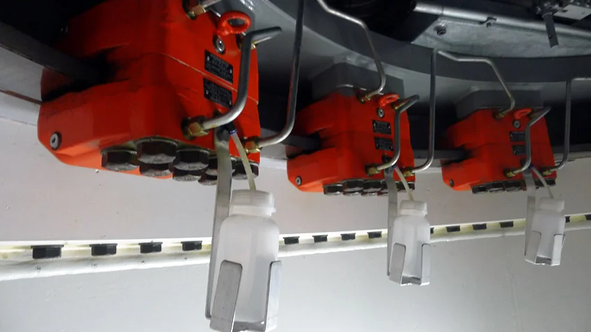 Des freins permettent de bloquer l’orientation de la nacelle dans la position optimale de fonctionnement de l’éolienne. Les petites bouteilles suspendues en-dessous de ces freins servent à recueillir les surplus d’huile.